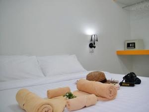 Una cama con dos toallas enrolladas encima. en Harmony Bed & Bakery, en Ko Lipe