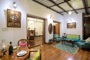 a living room filled with furniture and a table at SaffronStays Milton Abbott Estate, Ooty in Ooty