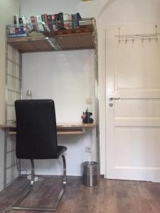 een bureau en een stoel in een kamer met een deur bij WOHLFÜHLOASE - Zimmer, Appartment - im Herzen STARNBERGS in Starnberg