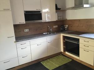 a kitchen with white cabinets and a sink at Haus Ranten 105 in Ranten