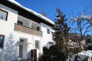 una casa blanca con nieve en el techo en Alpen - Apartments II, en Garmisch-Partenkirchen
