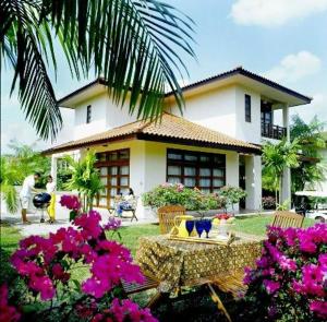 a house with pink flowers in front of it at Bintan Lagoon Resort in Lagoi