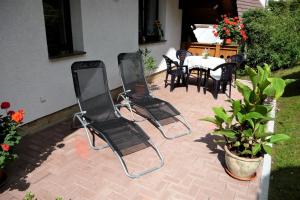 eine Terrasse mit 3 Stühlen, einem Tisch, einem Tisch und einem Chairsktop in der Unterkunft Ferienhaus Lupus in Schmalkalden
