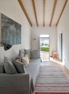 een woonkamer met een bank en een schilderij aan de muur bij Casa Iemanjá in Vila do Bispo