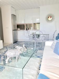 un soggiorno con tavolo in vetro e una cucina di The White Rock Private access to the beach a Torremolinos