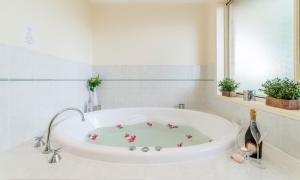 a white bath tub with flowers on it in a bathroom at The Carmel Yamba in Yamba