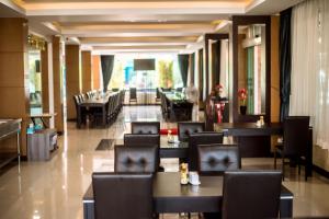 a restaurant with tables and chairs and a lobby at Blue Sky Residence Airport in Ban Bang Phli Yai