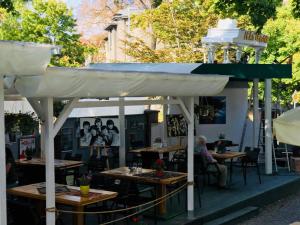 an outdoor restaurant with tables and a white canopy at Willa Sorrento in Szczecin