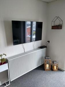 sala de estar con TV de pantalla plana en la pared en Bed and Breakfast i Struer, en Struer