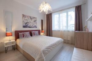 Un dormitorio con una cama grande y una lámpara de araña. en Two Bedroom Apartment Near to Doctors Garden en Sofía