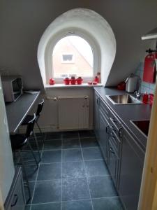 a kitchen with an arched window and a sink at Bed and Breakfast i Struer in Struer