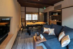ein Wohnzimmer mit einem blauen Sofa und einem Tisch in der Unterkunft Ainotsuji Machiya House in Kanazawa