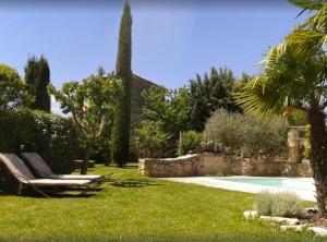 einen Garten mit einem Pool und einem Grasstuhl in der Unterkunft Le Petit Bastidon - Private pool - Gordes in Gordes