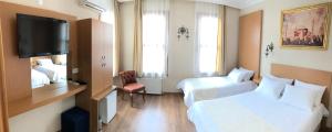 a hotel room with two beds and a flat screen tv at Ottoman's Pearl Hotel in Istanbul