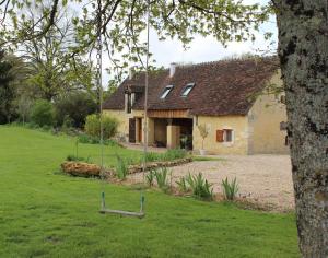 a swing in front of a house at Gîtes à l'ombre des chênes in Châteauvieux