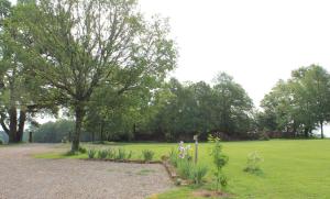een park met een grasveld en bomen bij Gîtes à l'ombre des chênes in Châteauvieux