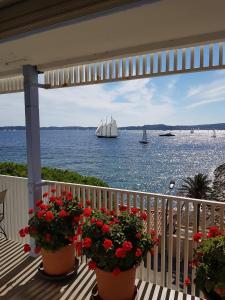 een balkon met een zeilboot in het water met bloemen bij Duplex de la Baie de st Tropez in Sainte-Maxime