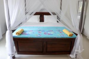 ein Schlafzimmer mit einem Himmelbett in der Unterkunft Sakura Calm Rest in Mirissa