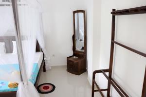 a small bedroom with a bed and a mirror at Sakura Calm Rest in Mirissa