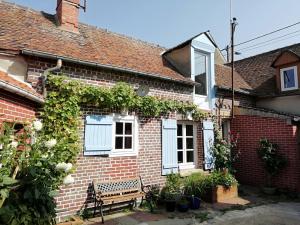 una casa de ladrillo con un banco delante de ella en La "charcuterie" GREBER en Beauvais