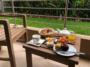 a table with a plate of fruit and a pitcher of orange juice at Hotel Elais Kinshasa in Kinshasa