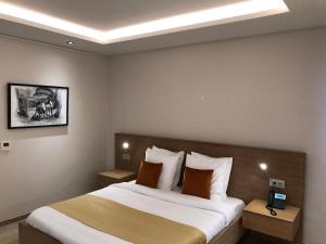 a bedroom with a large bed and two night stands at Hotel Elais Kinshasa in Kinshasa +19 photos