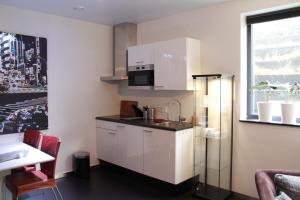 une cuisine avec des placards blancs et une fenêtre dans l'établissement WK12 STUDIO, à Cuijk