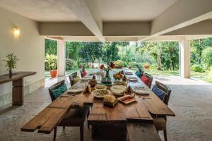 a dining room with a wooden table and chairs at SaffronStays Masaya, Alibaug - pet-friendly villa with alfresco dining in Alibaug