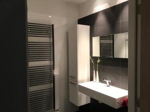 La salle de bains est pourvue d'un lavabo blanc et d'un miroir. dans l'établissement WK12 STUDIO, à Cuijk