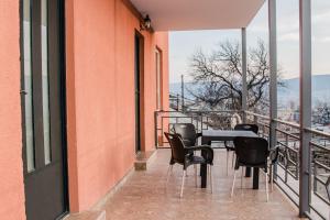 einen Balkon mit einem Tisch und Stühlen auf einem Gebäude in der Unterkunft Red Hotel in Tbilisi City