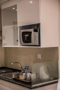 a kitchen counter with a microwave and a dishwasher at Naylover Hotel Suites in Amman