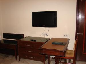 a room with a dresser and a flat screen tv on the wall at Mansingh Palace, Ajmer in Ajmer