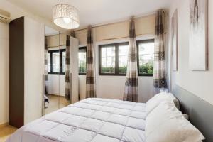 Un dormitorio con una cama grande y ventanas. en Florence Ognissanti Apartment, en Florencia