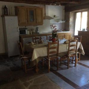 eine Küche mit einem Tisch und Stühlen sowie eine Küche mit einem Kühlschrank in der Unterkunft La maison d oscar in Menet