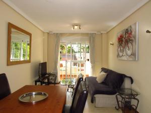 ein Wohnzimmer mit Sofa und Tisch in der Unterkunft Torreon del Mar Apartment in Benalmádena + 19 Fotos