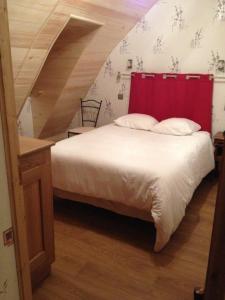 Bett mit rotem Kopfteil in einem Zimmer in der Unterkunft La maison d oscar in Menet