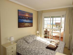ein Schlafzimmer mit einem Bett und einem Gemälde an der Wand in der Unterkunft Torreon del Mar Apartment in Benalmádena