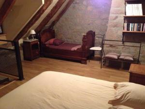 ein Schlafzimmer mit einem Bett und eine Treppe mit einer Treppe in der Unterkunft La maison d oscar in Menet