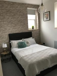 1 dormitorio con 1 cama grande y pared de ladrillo en 1 bed river apartment on the docks, en Gloucester