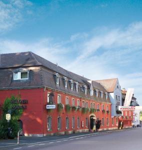 un edificio rojo al lado de una calle en Hotel Wilder Mann, en Aschaffenburg