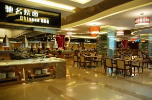 un ristorante con tavoli e sedie in un centro commerciale di Yun'an Huidu Hotel a Kunming