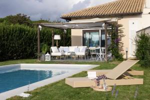 un patio trasero con piscina y una casa en Villetta Golf al Mare, en Porto Clementino