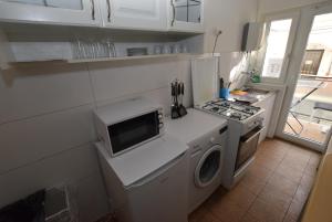 a kitchen with a microwave and a washing machine at Stuttgart Bad Cannstatt in Stuttgart