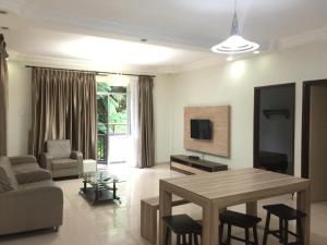 a living room with a table and a tv at Cameron Supersave Apartment @ Crown Imperial Court in Brinchang