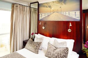 una camera d'albergo con un letto con una foto appesa al muro di First Group The Palace All-Suite a Durban