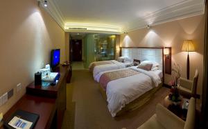 una camera d'albergo con due letti e una televisione di Yun'an Huidu Hotel a Kunming
