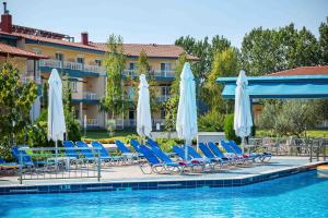 uma piscina com espreguiçadeiras e guarda-sóis em Grand Platon Hotel em Olympiakí Aktí