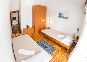 Guest House Mandarina في بودفا: غرفة صغيرة بسريرين ومرآة