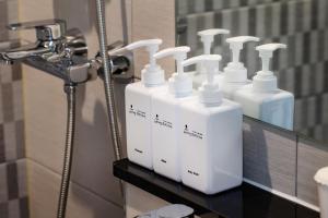 首爾的住宿－Five hotel Jongno，浴室内柜台上的一组白皂液器