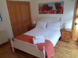 una camera da letto con un letto bianco con due asciugamani di Fountainbridge Flat a Edimburgo